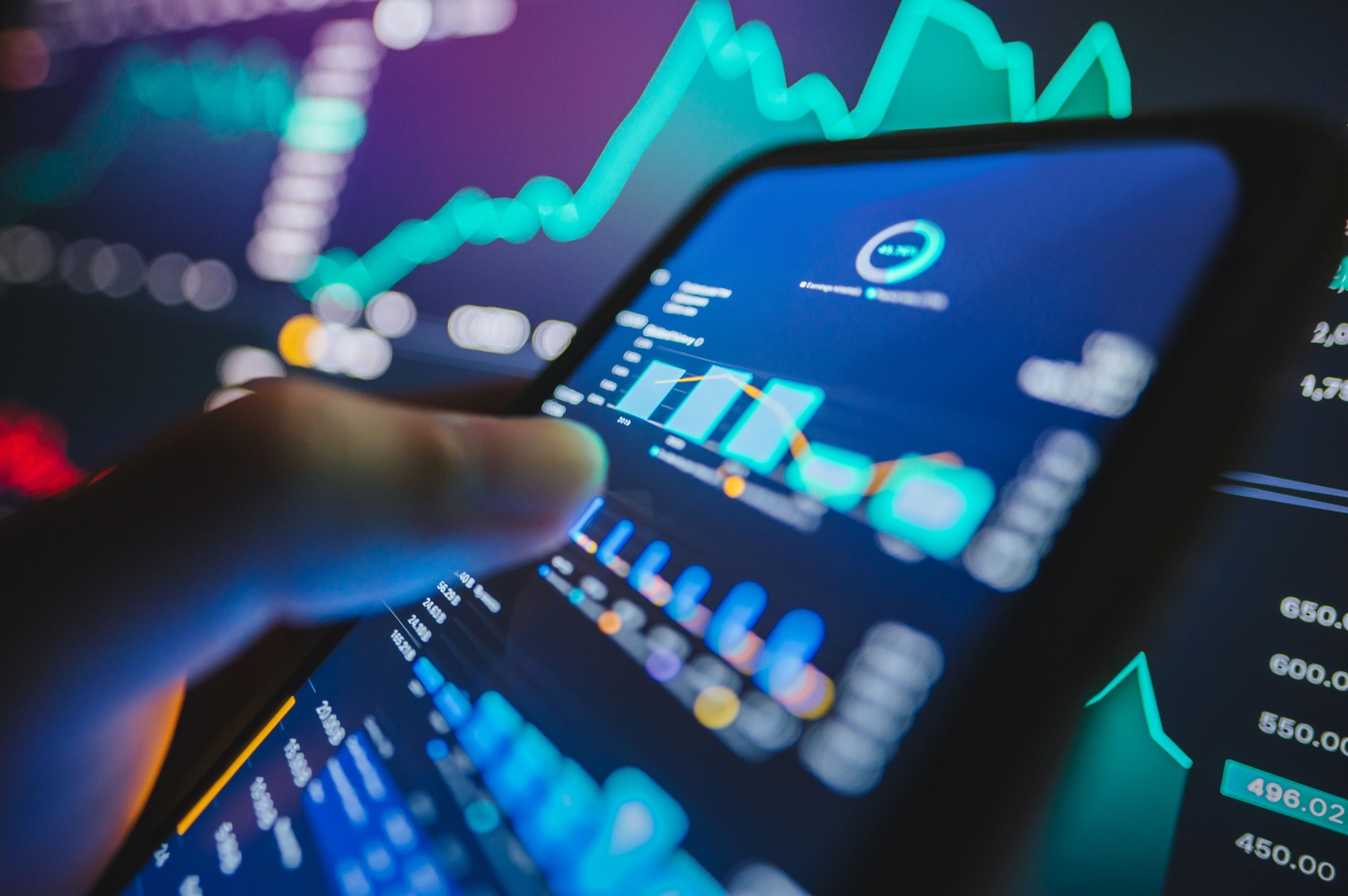 A business professional using a tablet artificial intelligence model charts displaying a smart trading interface powered AI  with detailed charts and graphs for informed trading decisions